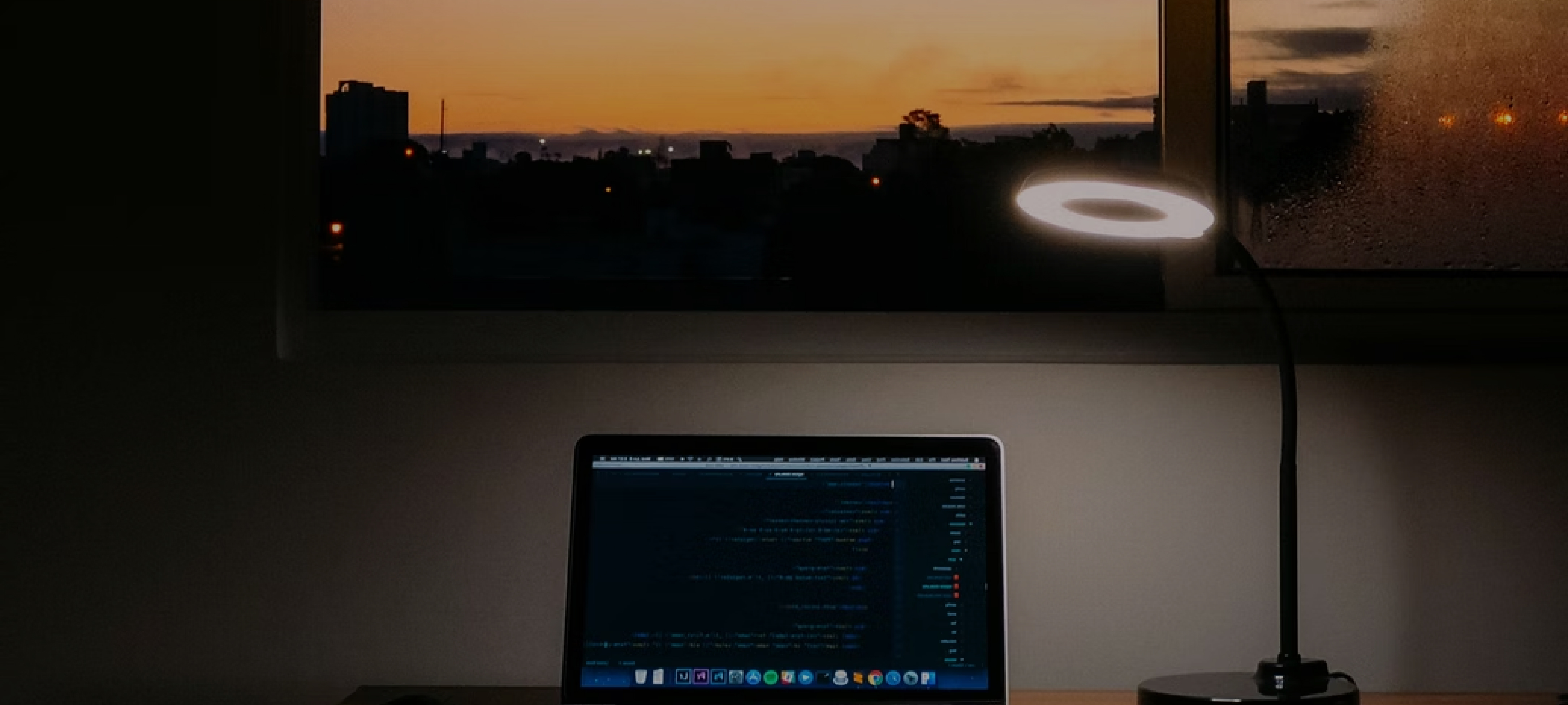 A laptop on a desktop at sunset